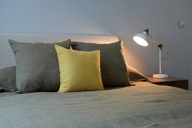 istock Cozy bedroom interior with pillows and reading lamp 484841352