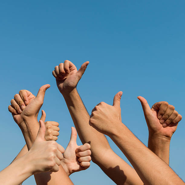 istock Hands giving thumbs up over blue sky 484841616