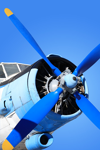 Closeup of old airplane engine with propeller against blue sky. Isolated with clipping path