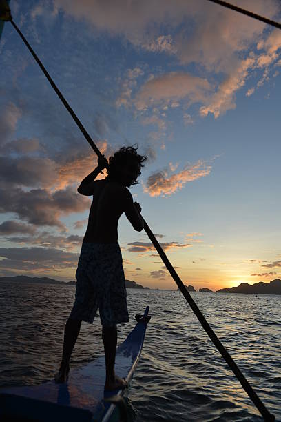 philippino sulla sua tradizionale banca canoa con bilanciere imbarcazioni nelle filippine - nautical vessel philippines mindanao palawan foto e immagini stock