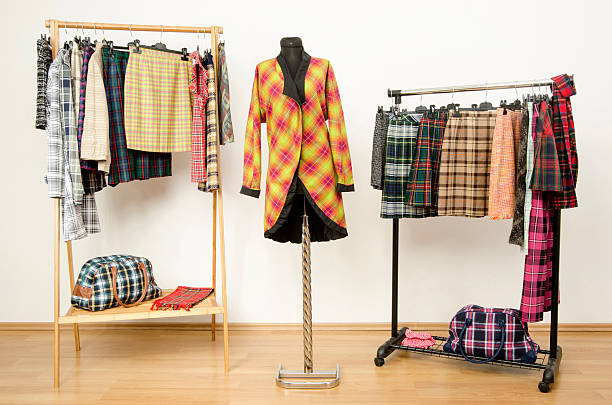istock Dressing closet with plaid clothes arranged on hangers. 484845938