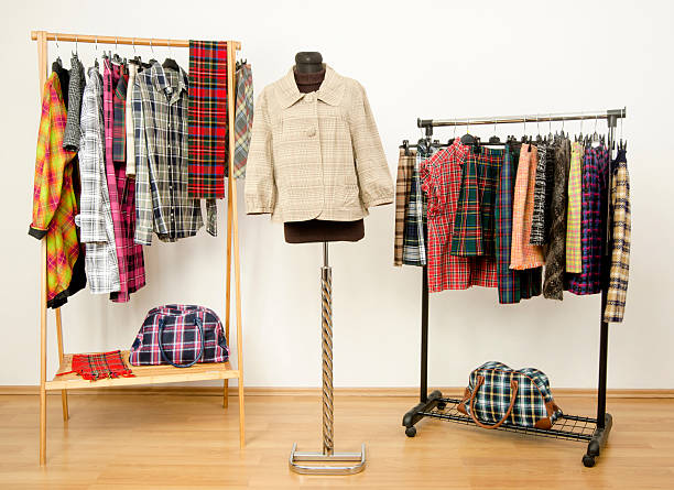 istock Dressing closet with plaid clothes arranged on hangers. 484845960