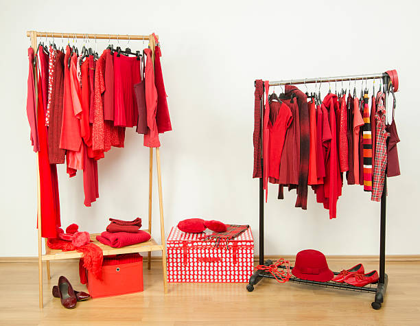 istock Wardrobe with red clothes hanging on a rack nicely arranged. 484845976