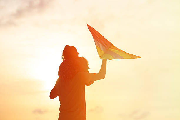 istock father and little daughter flying kite at sunset 484846062