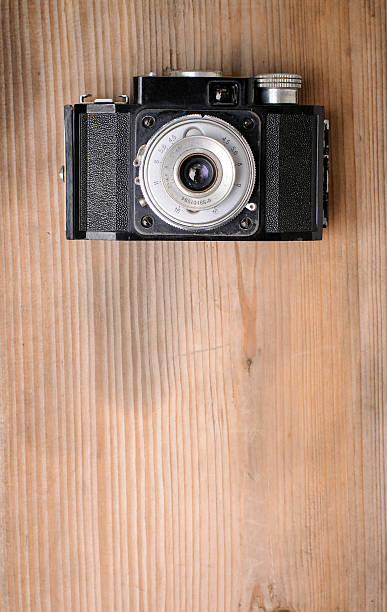 istock retro camera on wooden background 484851142