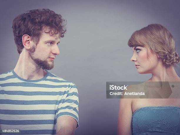 Woman And Man Sitting On Sofa Looking To Each Other Stock Photo - Download Image Now