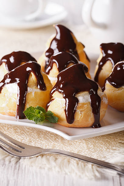 istock profiteroles with cream and chocolate glaze on a plate. vertical 484867310