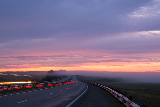 istock fog on the road during sunrise 484870180