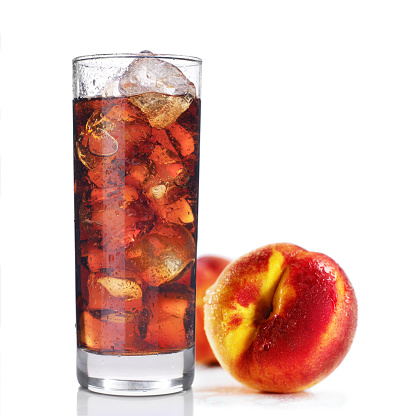 Glass full of ice tea with peach fruit, isolated on white background