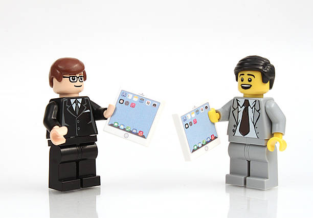 Business with Tablets Colorado, USA - June 11, 2015: Studio shot of Lego minifigure businessman with tablets. Legos are a line of plastic construction toys manufactured by The Lego Group, a company based in Denmark. lego stock pictures, royalty-free photos & images