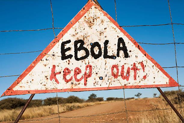 Ebola keep out old rusty warning triangle at a fence in Africa  with the words Ebola keep out ebola stock pictures, royalty-free photos & images