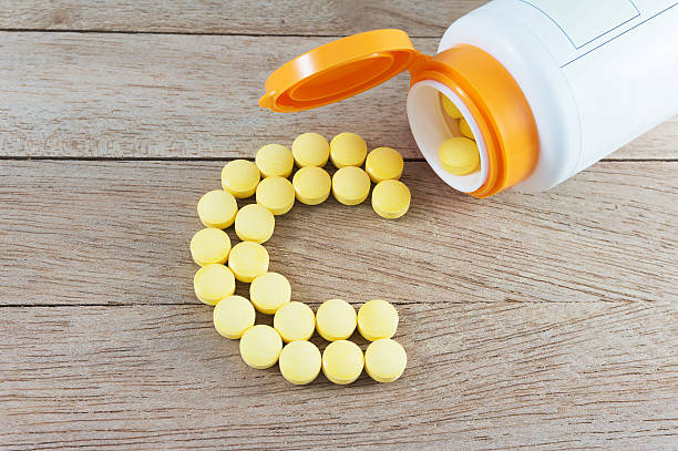 Yellow pills forming shape to C alphabet on wood background Yellow pills forming shape to C alphabet on wood background pellet gun stock pictures, royalty-free photos & images