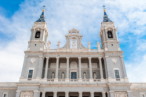 MADRID SPAIN - JUNE 23, 2015: Cathedral of Saint Mary the Royal of La Almudena on the blue sky background with white clouds in Madrid, Spain.