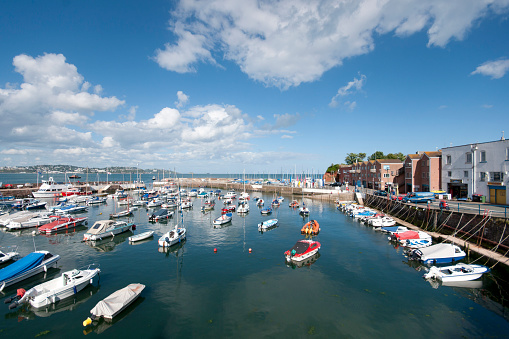This is Paignton harbour, a popular seaside town in south Devon with the tide in and lots of boats present. Over the other side of the bay is Torquay.
