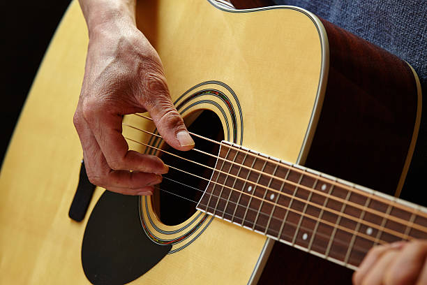 istock Man playing acoustic guitar at home 484902771