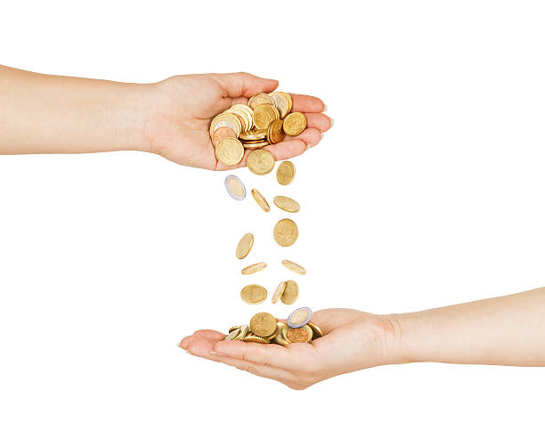 istock Female hand pour down coins into hands of another person. 484905152