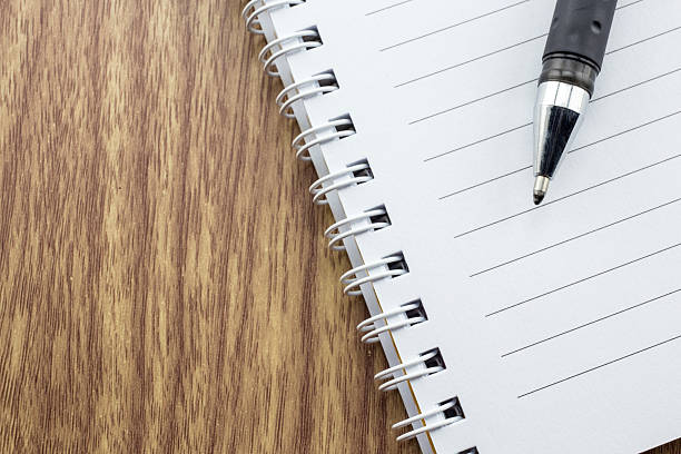 istock notepad with pen lying on the wooden table 484905898