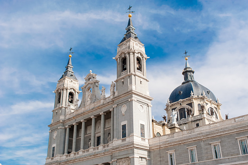 MADRID SPAIN - JUNE 23, 2015: Cathedral of Saint Mary the Royal of La Almudena on the blue sky background with white clouds in Madrid, Spain.