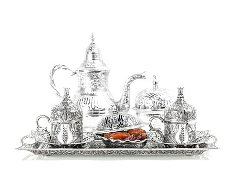 Silver tableware and dates. Oriental hospitality concept with tea or coffee cups