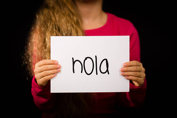 istock Child holding sign with Spanish word Hola - Hello 484909510