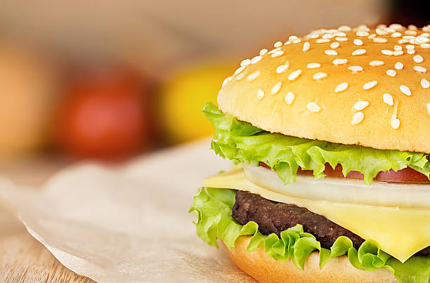 istock Delicious hamburger on brown paper on a wooden tabletop 484909560