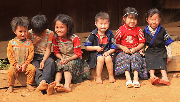 Mu Cang Chai, Vietnam - April 12, 2014: Vietnamese Hmong children looking at visitor's camera under the sunlight while playing on a playground in their village in Mu Cang Chai district, northwest of Vietnam.