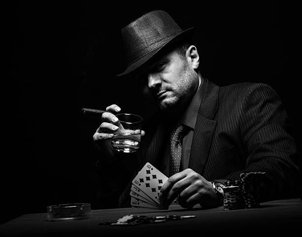 Male gambler playing poker. Male gambler playing poker and smokes a cigar, Black and white texas hold em photos stock pictures, royalty-free photos & images