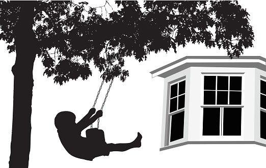 A vector silhouette illustration of a young boy swinging on a tree swing infront of his home where only a window shows.