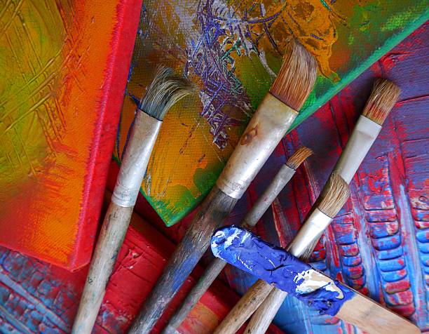 Painting brushes stand against the background of the easel. Painting master class. Shop of goods for creativity