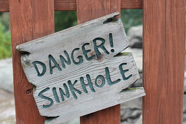 Danger Sinkhole sign Danger Sinkhole sign sinkhole stock pictures, royalty-free photos & images