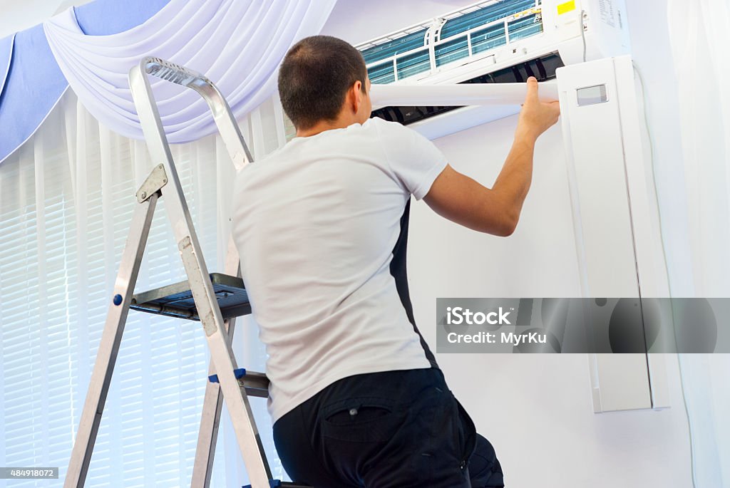 cleaning the air conditioner man cleans the air conditioning 2015 Stock Photo