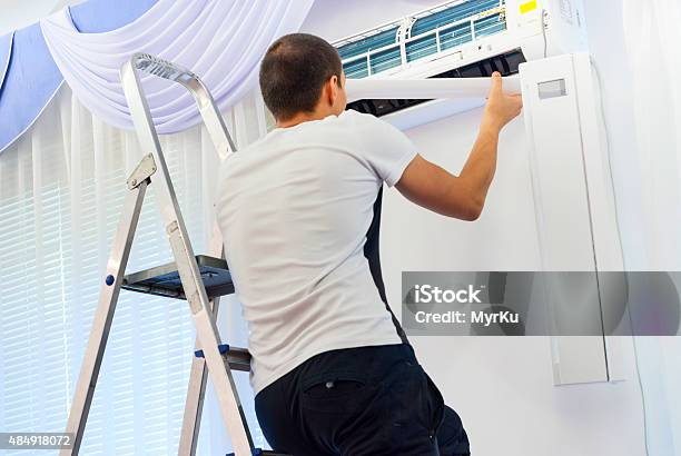 Cleaning The Air Conditioner Stock Photo - Download Image Now - 2015, Adult, Cleaning