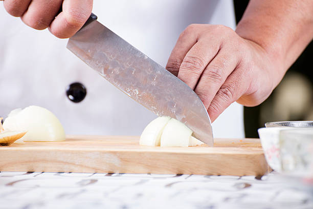 istock Chef cutting the onion on a wooden board 484922310