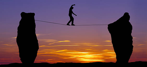 istock Silhouette of a man walking on the tightrope 484922566