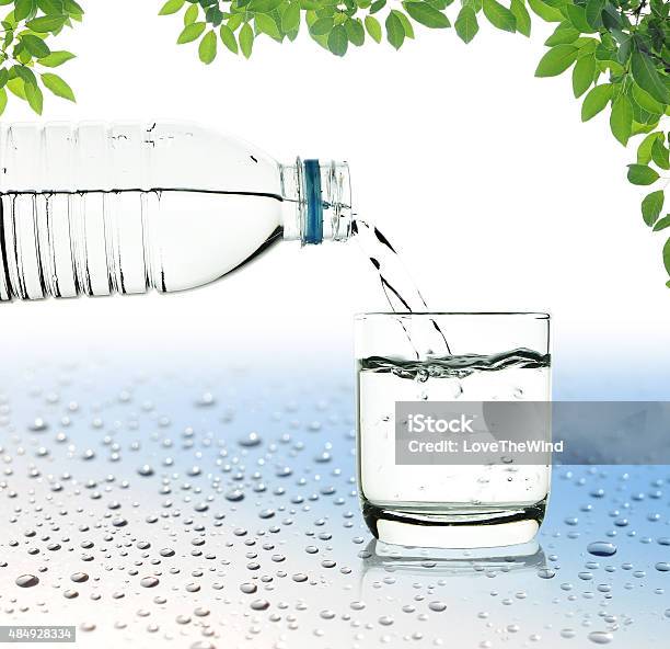 Drinking Water Is Poured From A Bottle Into A Glass Stock Photo - Download Image Now