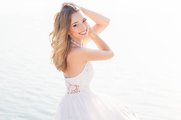 Beautiful smiling young bride girl over the sea view stock photo