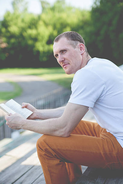 istock Cute   man reading outdoor 484937398