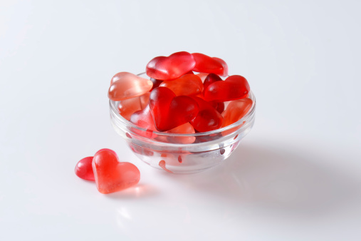 bowl of gelatin heart candies on white background