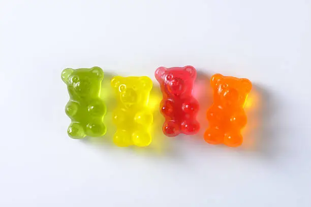 four multicolored gummy bears isolated on white background