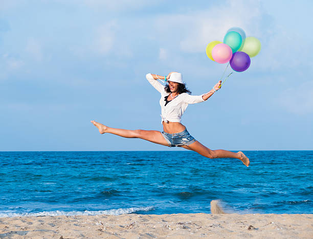 istock Young woman jumping with  balloons 484949688