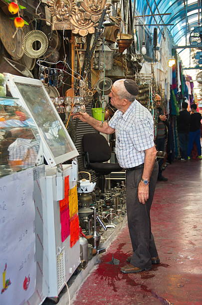 Jaffa, Israel - April 11, 2014:  An elderly gentleman examining merchendize in the Old City Arab Jaffa Market on Friday morning
