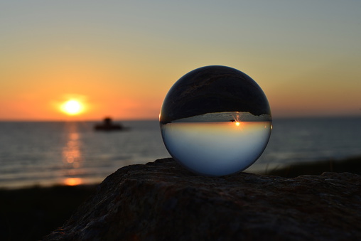 A crystal ball at sunset by the sea.