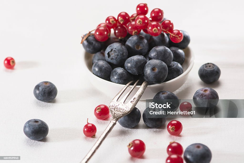 Blueberries and red currants Mix of blueberries and red currants scattered on the table 2015 Stock Photo