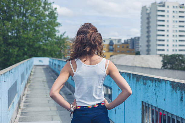 istock Young woman standing on a footbridge 484960026