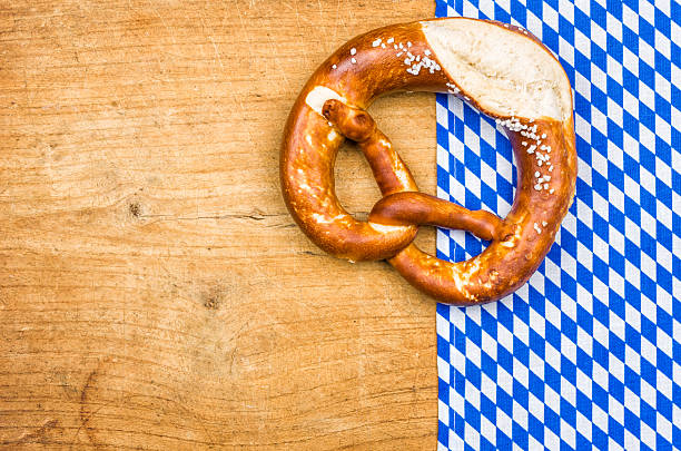 istock Pretzel with bavarian tablecloth on a wooden background 484960276