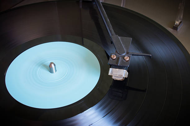 istock Rotating vinyl record with blue label on a turntable close-up 484966952