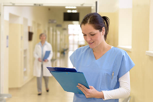 istock Nurse in hospital looking at file 484971884