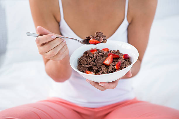 istock Attractive woman eating cereal in her bed 484971920