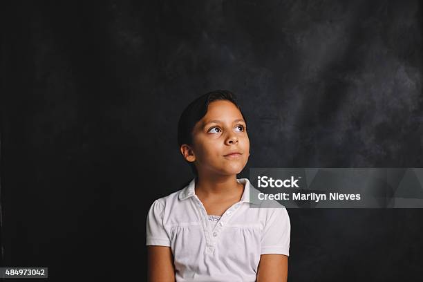 Young Female Student Sitting In Front Of Blank Blackboard Stock Photo - Download Image Now