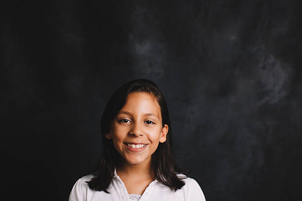 istock smiling elementary schoolgirl in front of blackboard 484973044